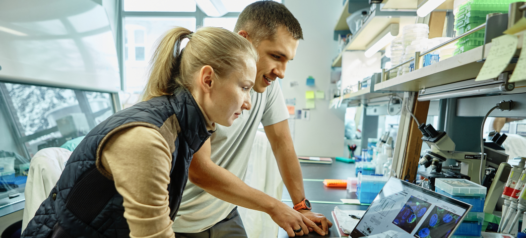 A man and woman looking at a computer