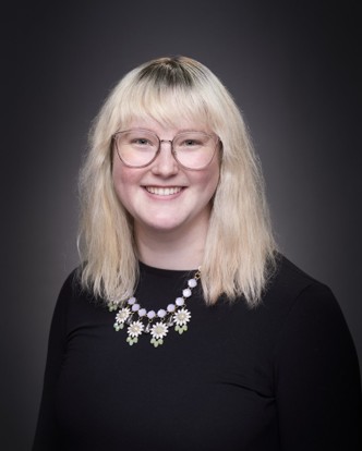 Kellie woman with blonde hair and glasses smiling